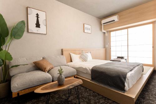 un dormitorio con una cama y un sofá en b&難波3号店, en Osaka