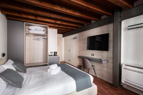 a bedroom with a large white bed and a flat screen tv at GuestHost - Santo 86 Luxury Rooms in Padova