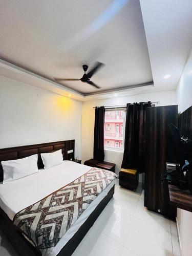 a bedroom with a bed and a ceiling fan at Hotel Wisteria Haridwar in Haridwār