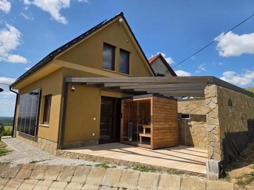 a small house with a stone wall at Vinárska chata in Trnovec