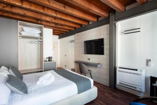a bedroom with a bed and a flat screen tv at GuestHost - Santo 86 Luxury Rooms in Padova