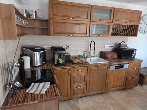 a kitchen with wooden cabinets and a counter with a sink at Vinárska chata in Trnovec