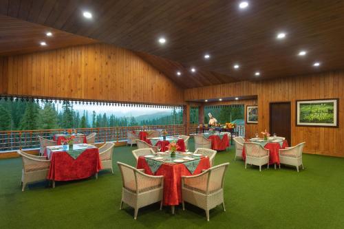 a restaurant with tables and chairs in a building at The Khyber Himalayan Resort & Spa in Gulmarg