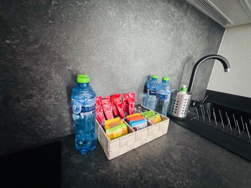 a sink with two bottles of water and a basket of food at Rodzinny Apartament przy plaży, Bezpłatny parking Dąbki in Dąbki