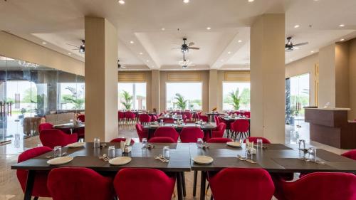 a large dining room with red chairs and tables at Pallacia A Luxury Hotel in Beāwar