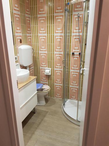 a bathroom with a toilet and a glass shower at Suite Rivabella Rimini in Rimini