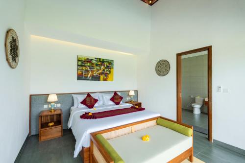 a bedroom with a large bed and a bathroom at Alam Dana Ubud in Ubud