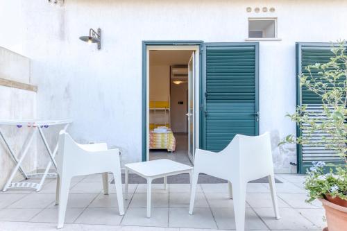 a patio with white chairs and a table at bed and breakfast Tallyho in Salve