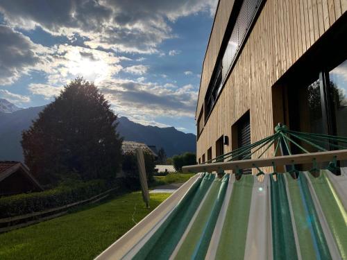 a hammock outside a building with a view of mountains at Haus Albuin in Sankt Gallenkirch