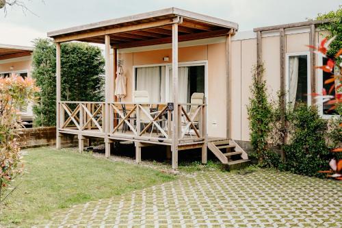 a house with a large deck with a patio at Camping Del Sole Village in Iseo