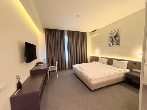 タシュケントにあるHanra Stayのベッドとテレビがあるホテルの部屋