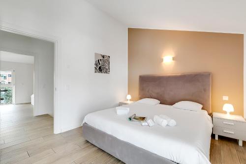 a bedroom with a large white bed and two lamps at Viganello Modern Apartments in Lugano