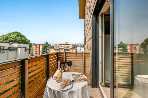a balcony with a table with wine glasses on it at Viganello Modern Apartments in Lugano