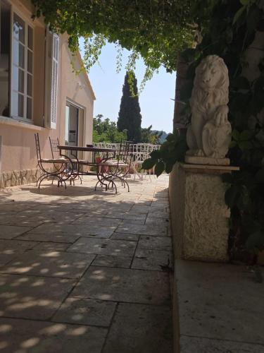 une statue d'un lion assis à côté d'un patio dans l'établissement Villa Manoa, à Ollioules