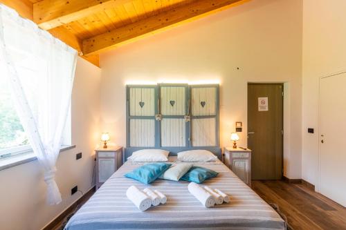 a bedroom with a large bed with blue and white pillows at HOTELLERIE VALLE SACRA in Cintano