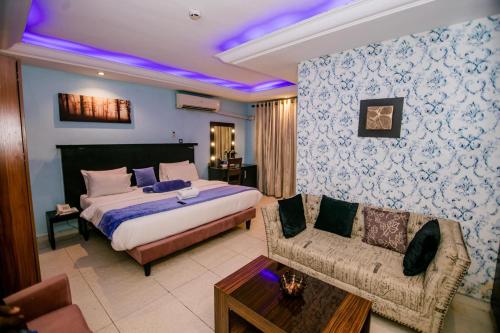 a bedroom with a king sized bed and a couch at Elegance Suites Hotels in Lagos