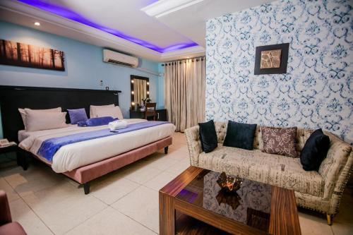 a hotel room with a bed and a couch at Elegance Suites Hotels in Lagos