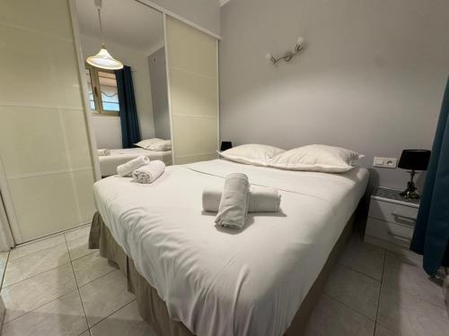 une chambre avec un grand lit avec des serviettes dessus dans l'établissement NEREIDES - Appartement 4 personnes avec Vue Mer exceptionnelle à Villefranche-sur-Mer, à Villefranche-sur-Mer