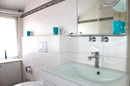 Un baño con lavabo, espejo y bañera. en Stilvolles Landhaus mit Flair, en Menslage