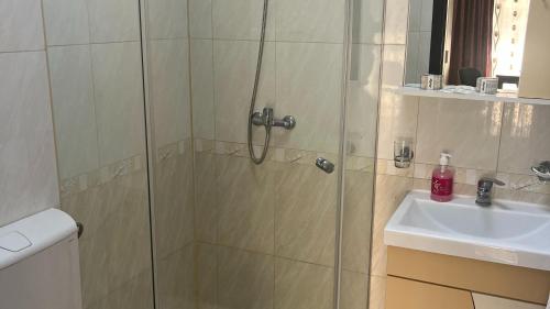 a shower with a glass door next to a sink at Cazare Mangalia - Self Check-in in Mangalia