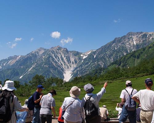 a group of people looking at a mountain range at Square 8 HAKUBA RETREAT by UNPLAN in Hakuba