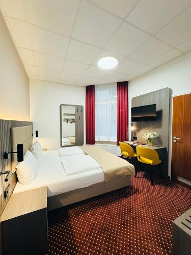 a hotel room with a large bed and a desk at Hotel Lumen am Hauptbahnhof in Hamburg