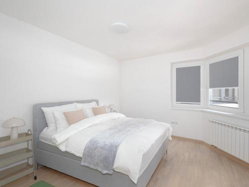 a white bedroom with a bed and a window at Skyline Residence Sarajevo Tower in Sarajevo