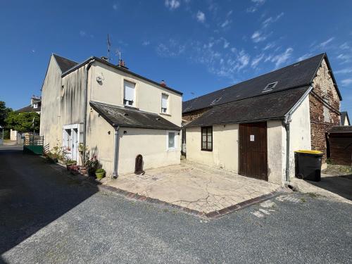 a large white building with a large garage at Les continents maison spacieuse 4 belles chambres parking privatif terrasse à 5 mn à pied tous commerces et 20 mn plage Omaha Beach et à 15 mn de Bayeux in Le Molay-Littry