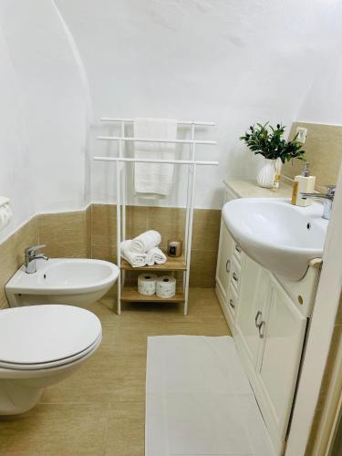 a white bathroom with a toilet and a sink at Mareincentro Vieste in Vieste