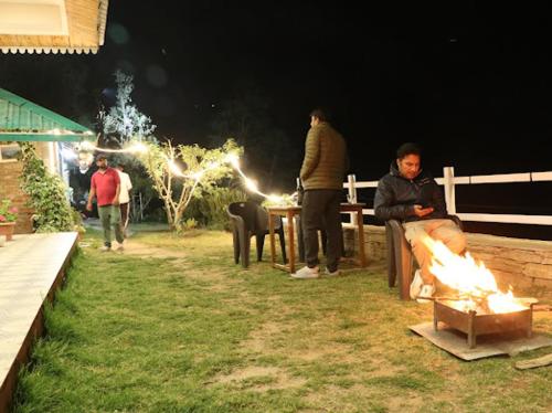 a group of people standing around a fire at night at Panet jungle home stay in Panuānaula