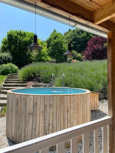 a circular pool in a wooden fence with two faucets at Landhaus Jule in Sankt Peter am Ottersbach