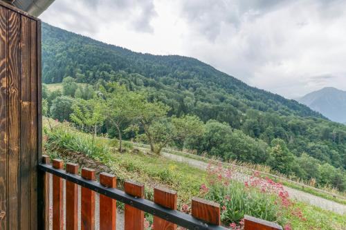 a view of a mountain with a fence and flowers at Chambre d'hôte Gite Passoud in Oz