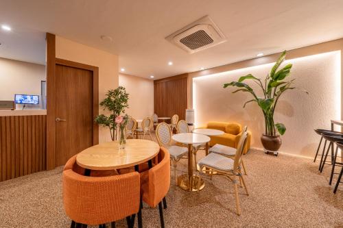 ソウルにあるHotel Firststay Hongdaeのテーブルと椅子のあるリビングルーム