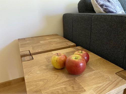 three apples on a wooden table next to a couch at Haus Albuin in Sankt Gallenkirch