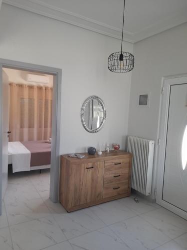 a room with a wooden dresser and a bedroom at Meteora view Guesthouse in Kalabaka