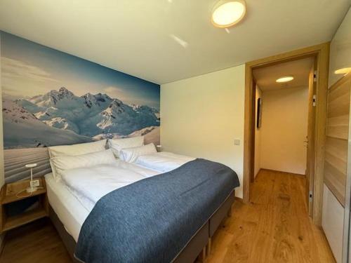 a bedroom with a large bed with a painting on the wall at Haus Albuin in Sankt Gallenkirch