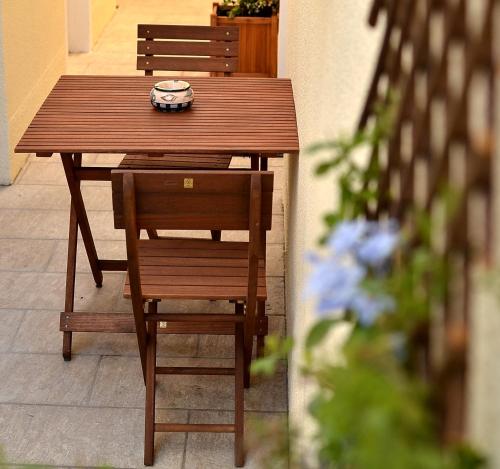 a wooden table with two chairs and a plate on it at Mistral Appartements in Saint-Louis-du-Rhône