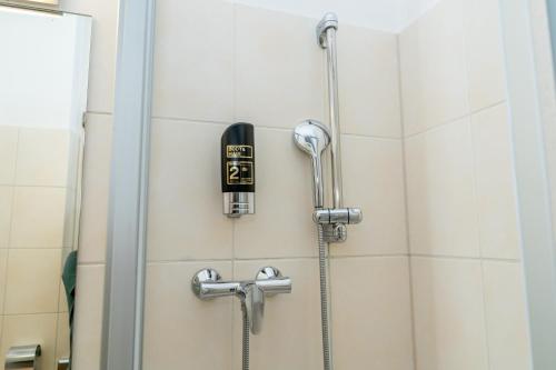 a shower with a blow dryer on the wall at Hotel Lumen am Hauptbahnhof in Hamburg