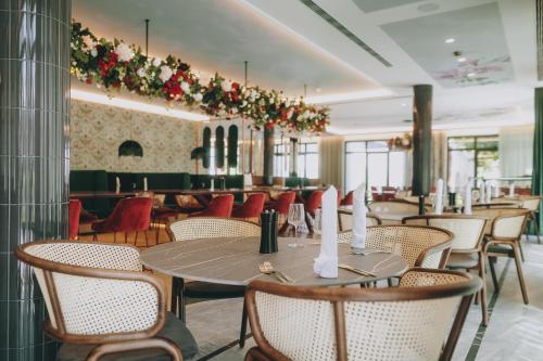 a restaurant with tables and chairs and flowers on the wall at Grand Elisabeth in Bad Ischl