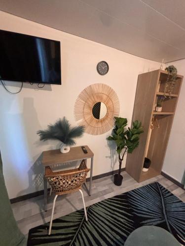 un salon avec une table et une télévision au mur dans l'établissement HÔTEL ORION, à Rouen