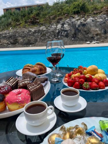 a table with plates of food and a glass of wine at Cascade Resort Sevan in Sevan