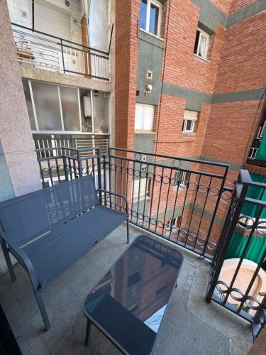 a balcony with a blue bench and a glass table at Piso de SIMBA cerca de playa, con piscina y varias terrazas in Lloret de Mar