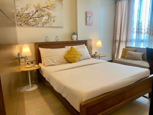 a bedroom with a large bed with yellow pillows at Flow 8 Suites at Mactan Newtown in Punta Engaño