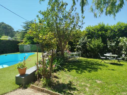 un jardin avec un arbre, une table et une piscine dans l'établissement Villa plein pieds 8 personne piscine reste semaine juillet août, à Simiane-Collongue