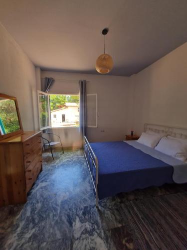 a bedroom with a bed and a large window at Modern traditional tranquil house with garden in Nea Makri