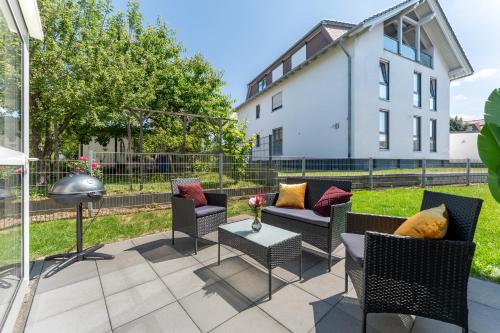 a patio with chairs and a table and a building at flair Apartment Blossom I BBQ I 2xParken I Terrasse I Kaffee I Waschmaschine I Disney plus in Fulda