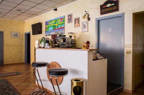 a bar in a restaurant with two stools at Hotel Parco Fiera in Turin