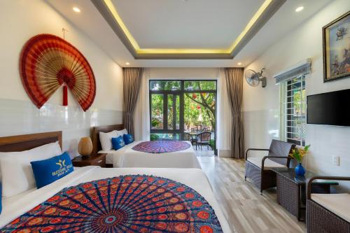 a hotel room with two beds and a living room at Blessing Villa Hoi An in Hoi An