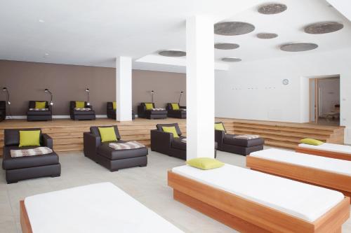 a waiting room with couches and chairs in a building at Hotel Cristal in Obereggen