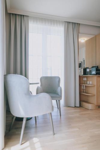 a white chair sitting in a room with a window at Grand Elisabeth in Bad Ischl